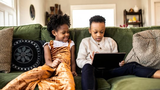 Telesoft Technologies a fait des normes la clé de sa stratégie - Un frère et une sœur regardent une tablette numérique sur le canapé à la maison.