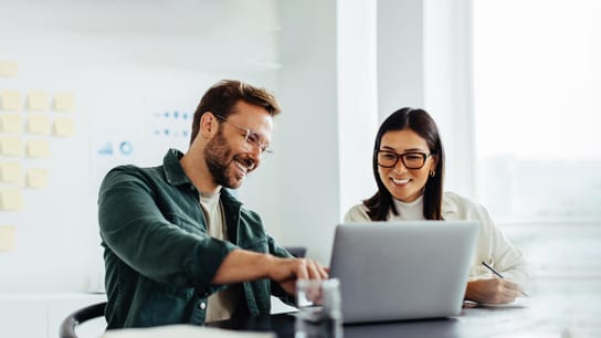 Two people behind a laptop.