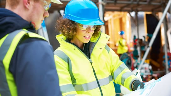 Women looking at plans on construction site 