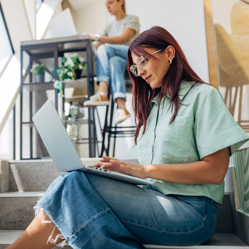 Happy female using laptop working outdoors, web conference, remote work concept.
