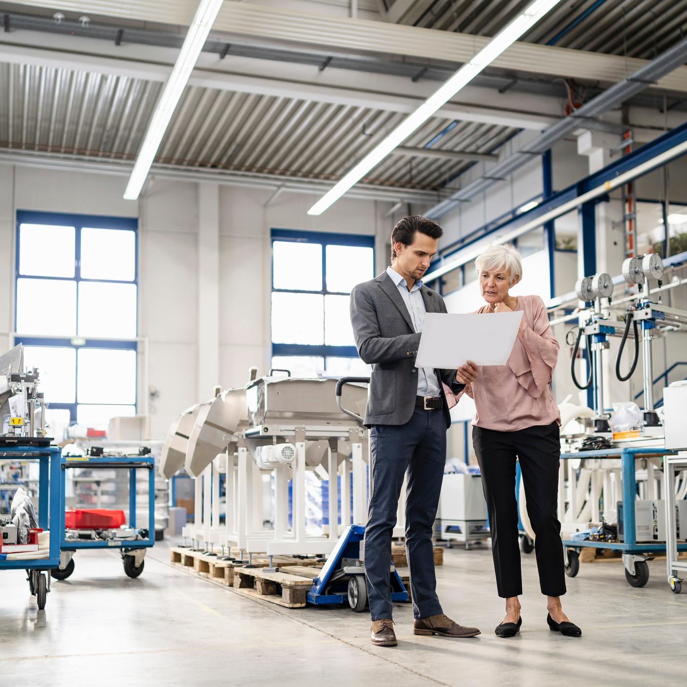 Collega's kijken naar een plan in een fabriek