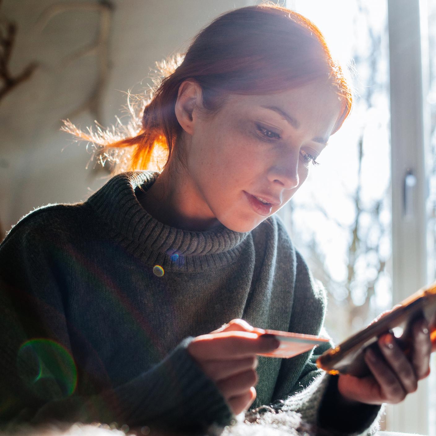 Kobieta robiąca zakupy online z laptopem i kartą kredytową w ręku