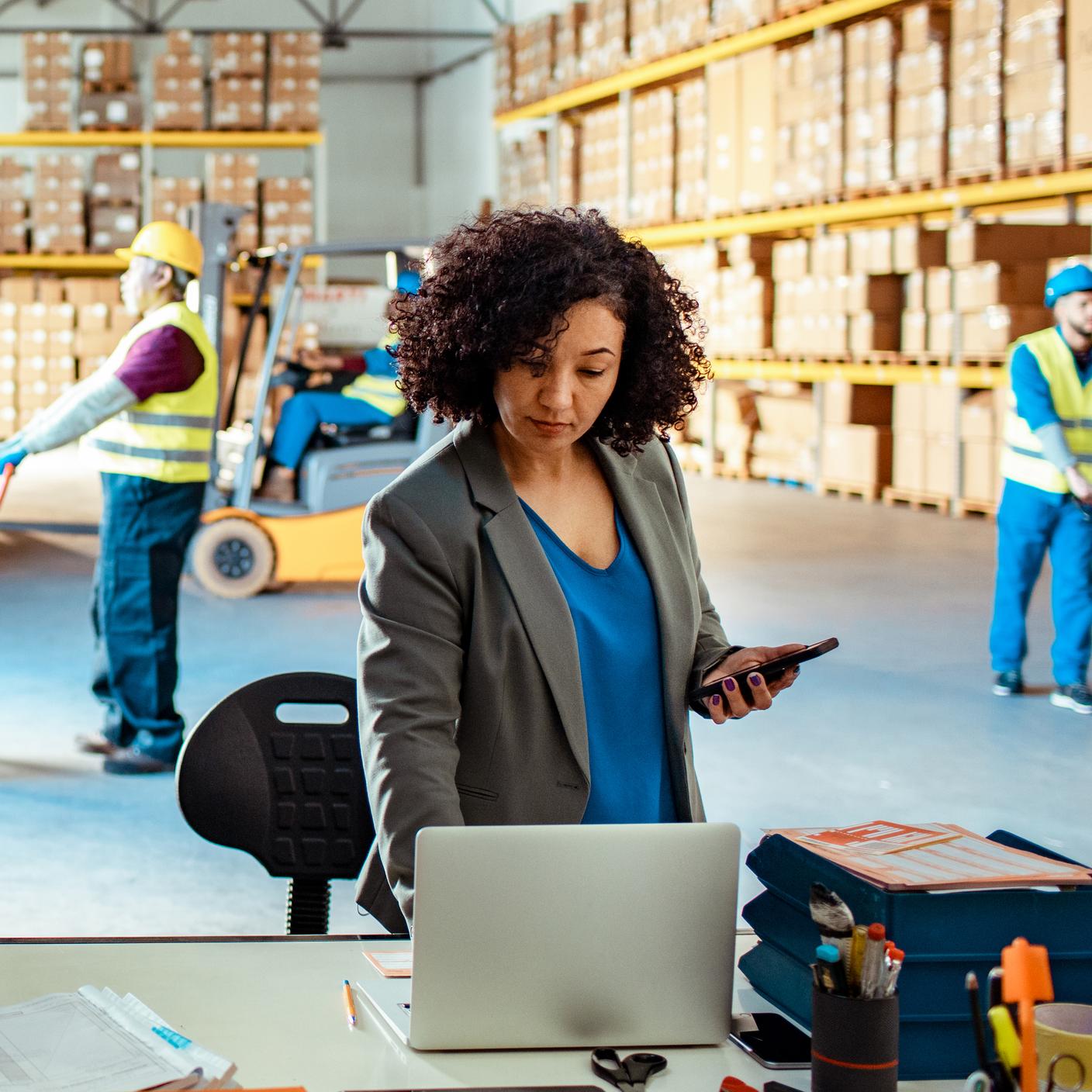 Close up of a warehouse manager using a laptop (cropped)
