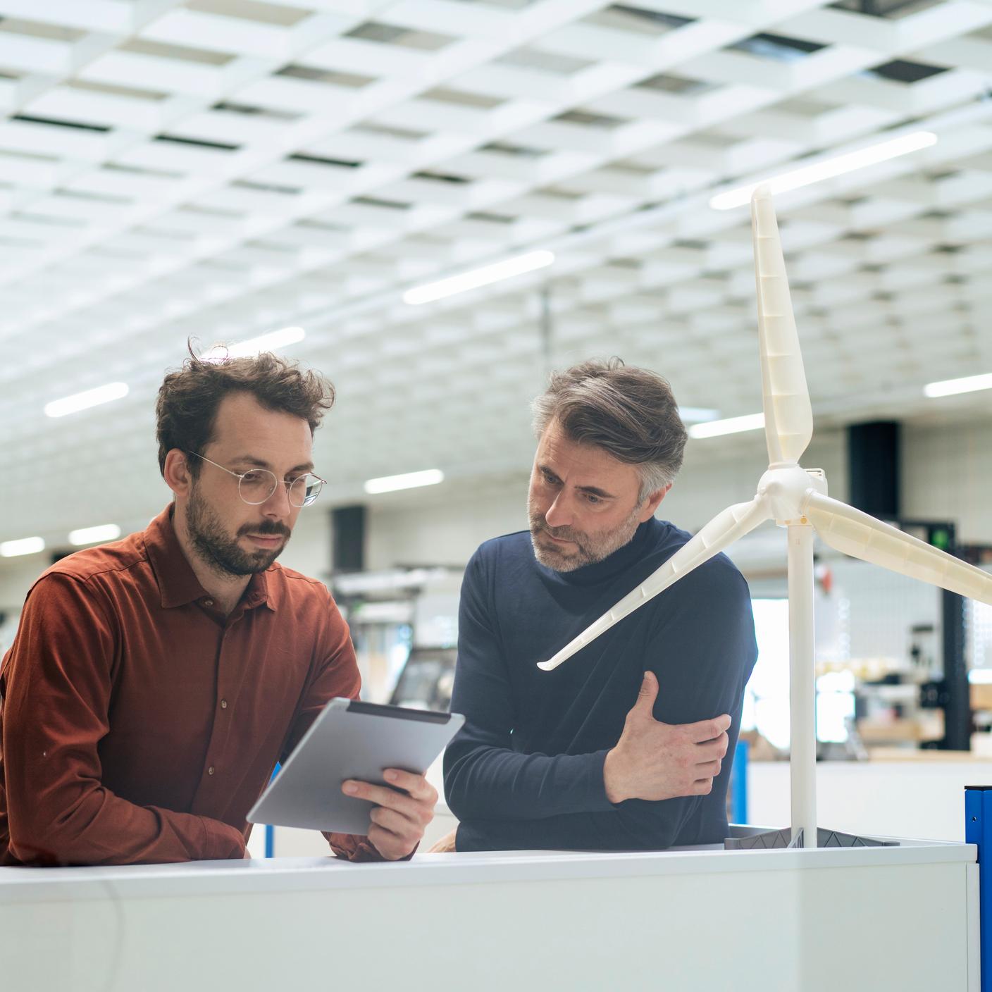 2 men looking at a tablet 