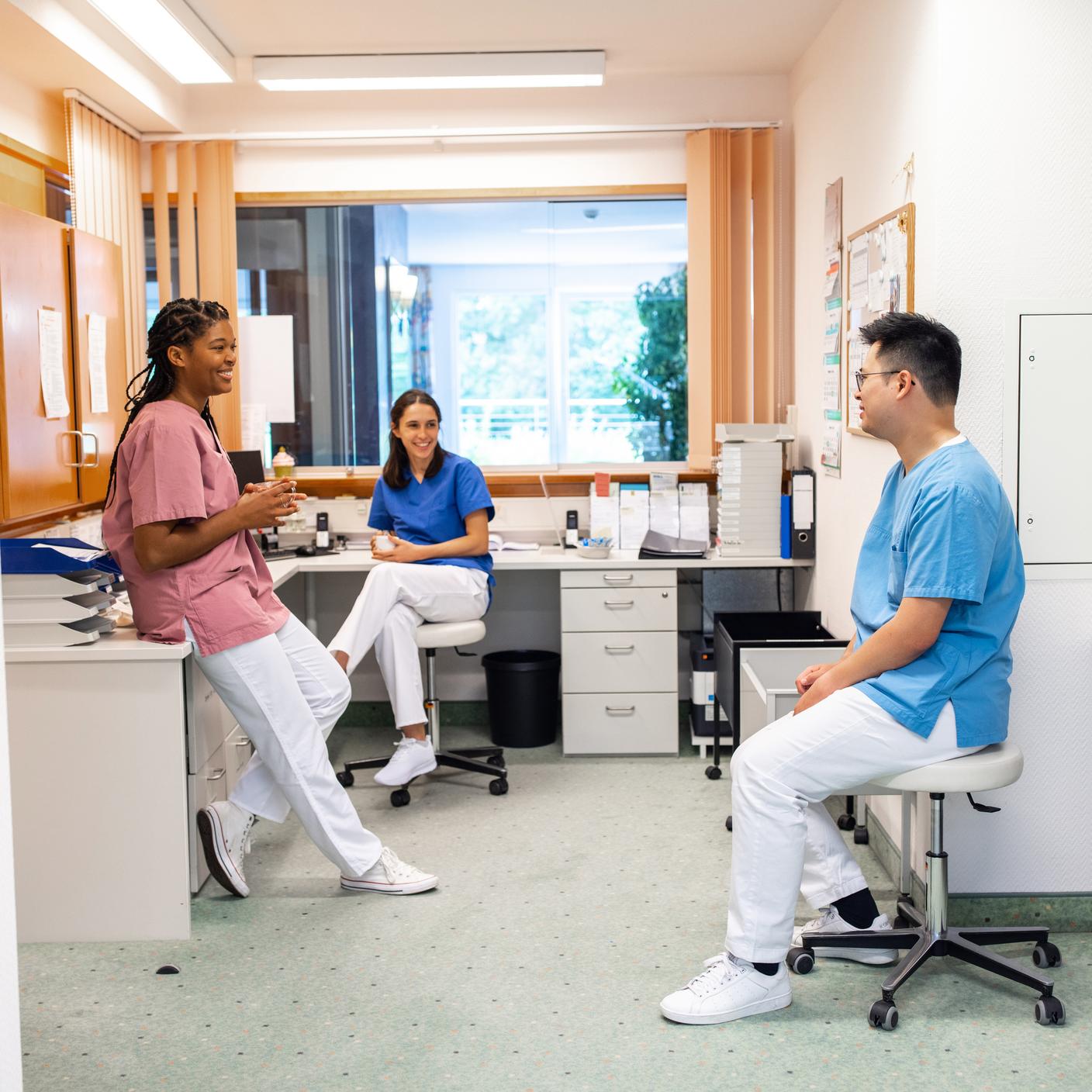 Schutz des Krankenhauspersonals nach COVID – Krankenhausmitarbeitende trinken Kaffee und unterhalten sich in der Pause
