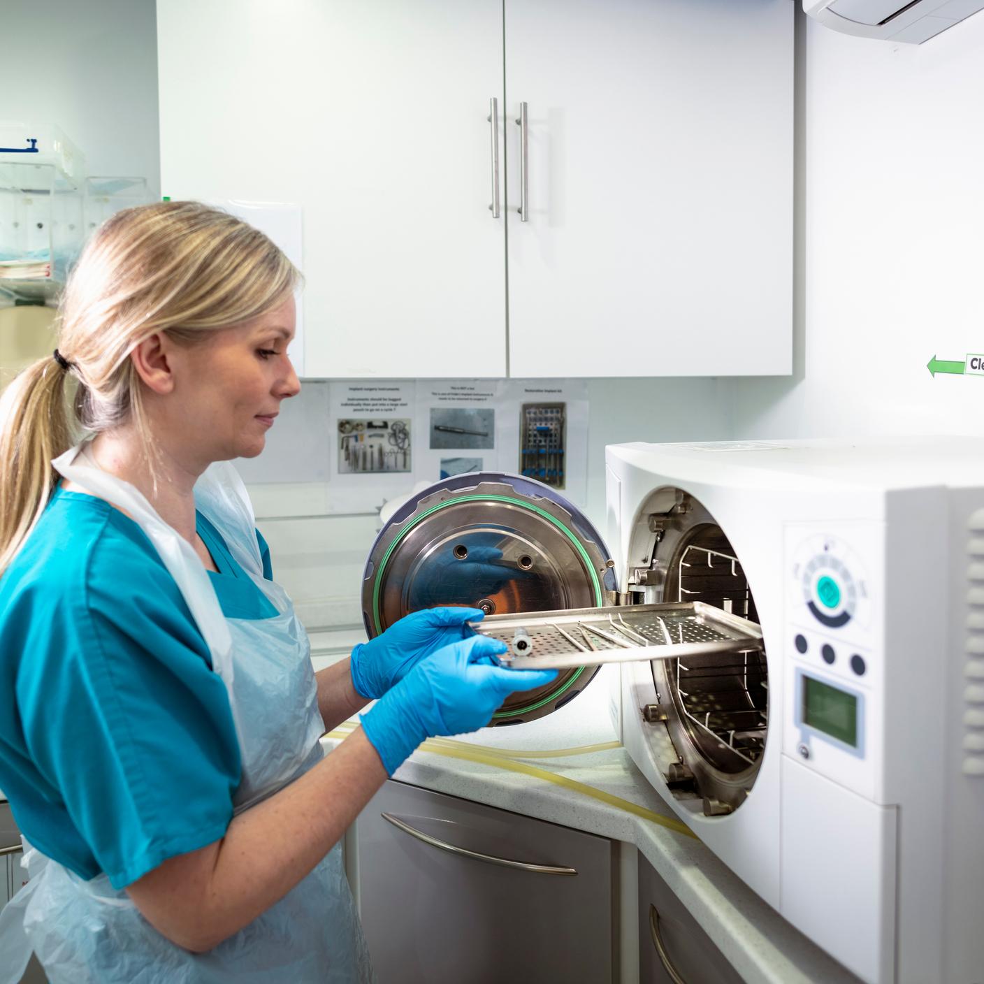 Personal médico esterilizando dispositivos médicos en una máquina de esterilización.