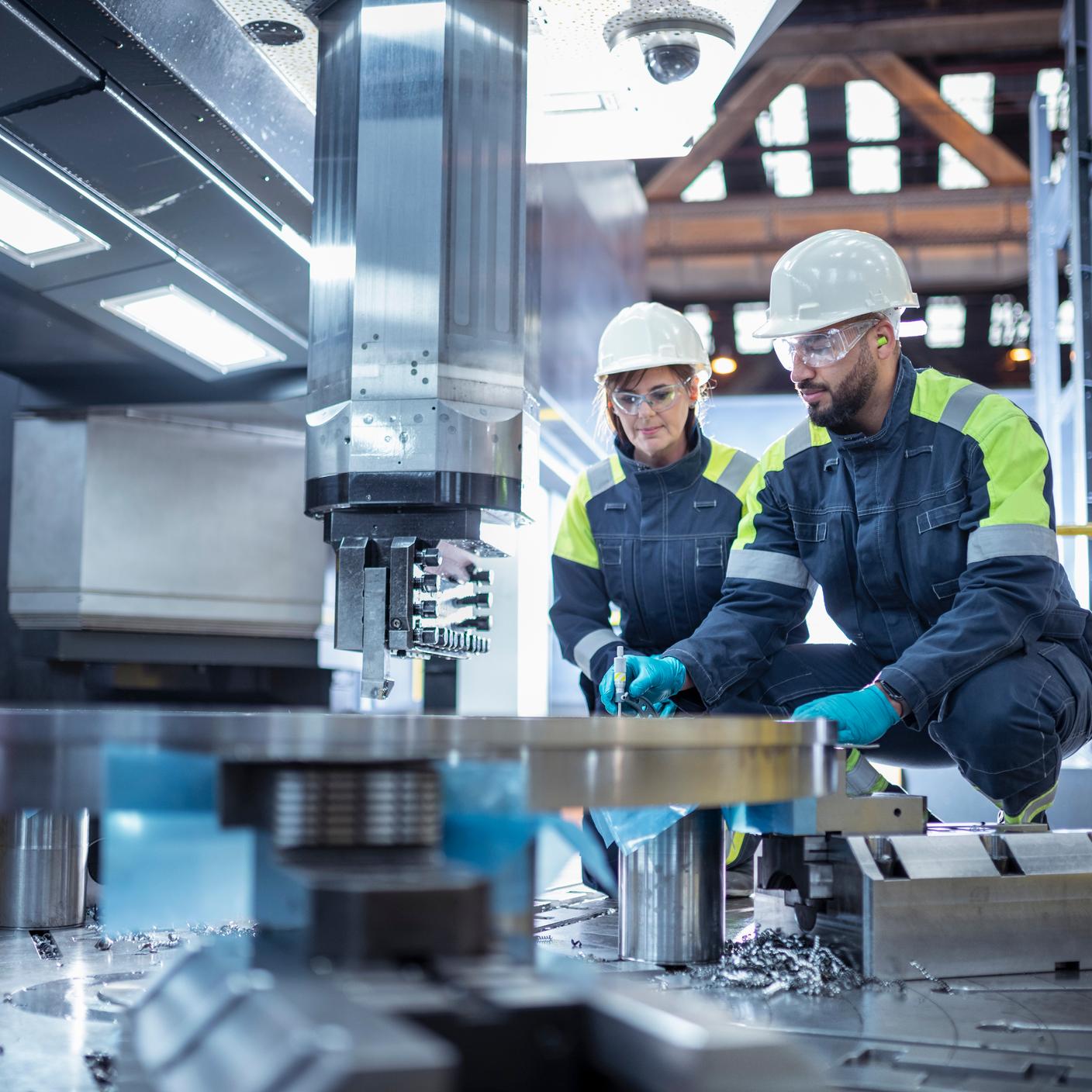 Male and female specialist lathe operators in steelworks.