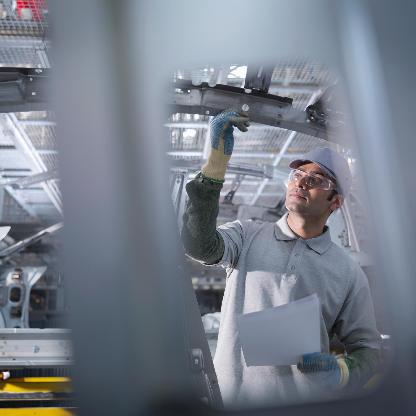 Trabajador de una fábrica de automóviles en la cadena de producción