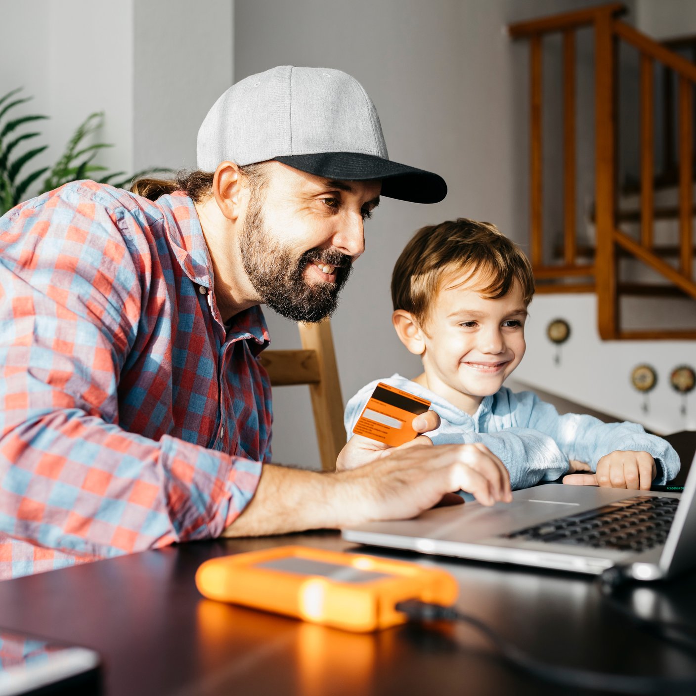Father and son using laptop together for online shopping