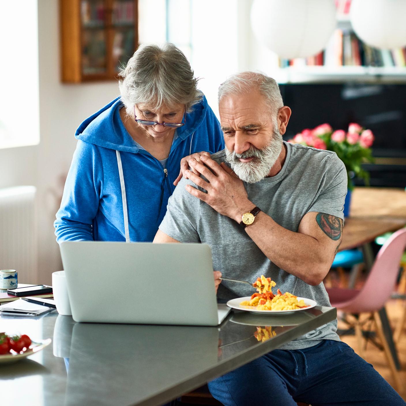 pareja de ancianos trabajando en una computadora portátil