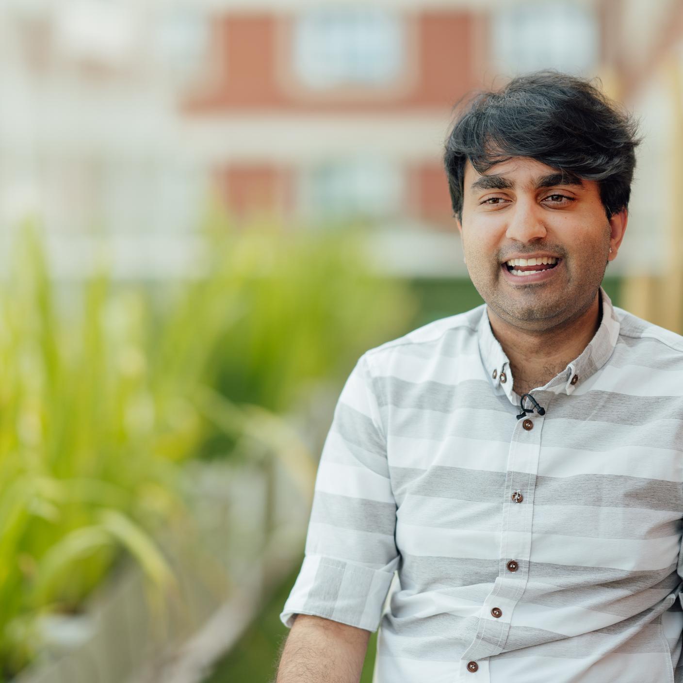 A man smiling in front of houses