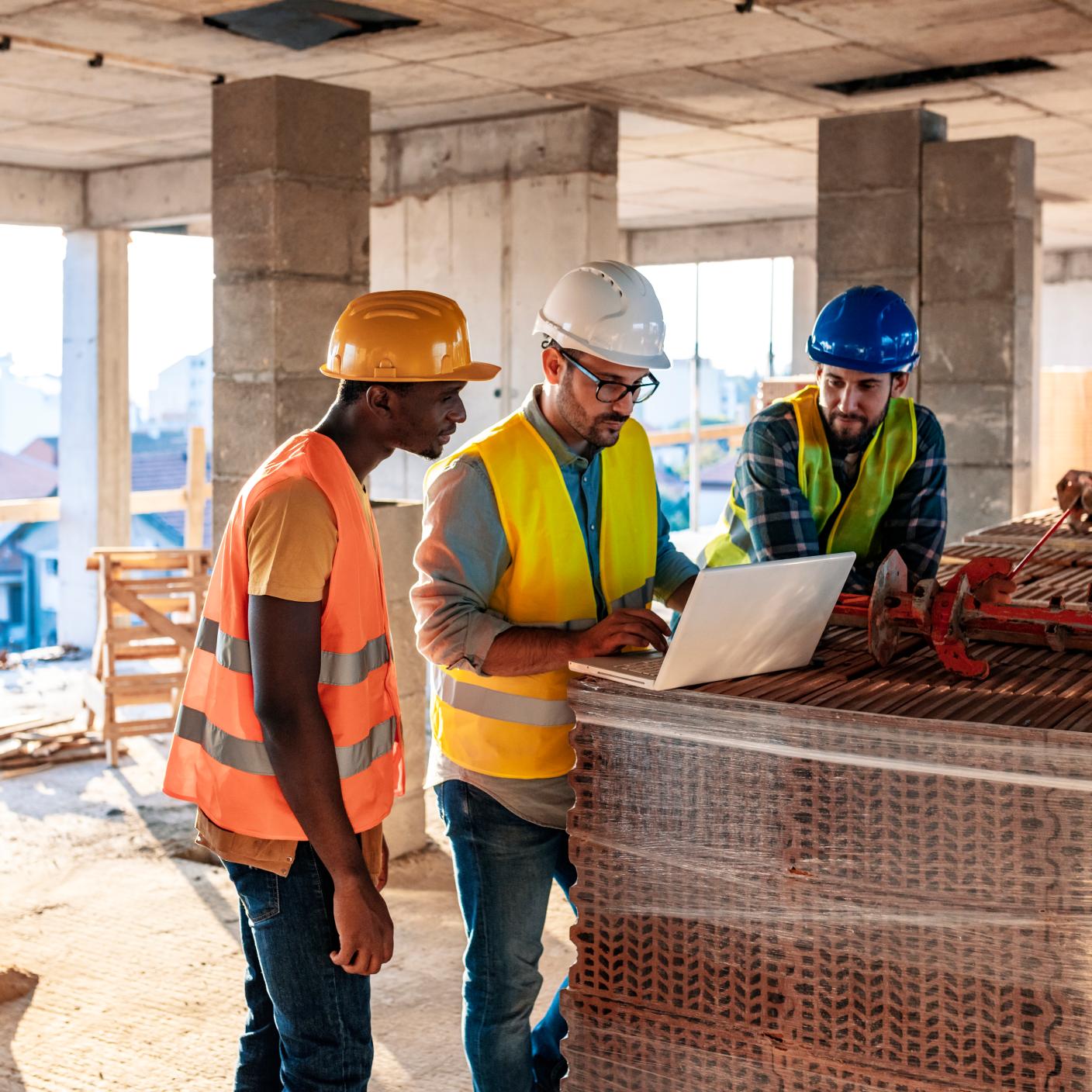 Engineer, architect and business man working on the engineering project at construction site. House building concept. Photo of young male architect engineer using laptop computer.