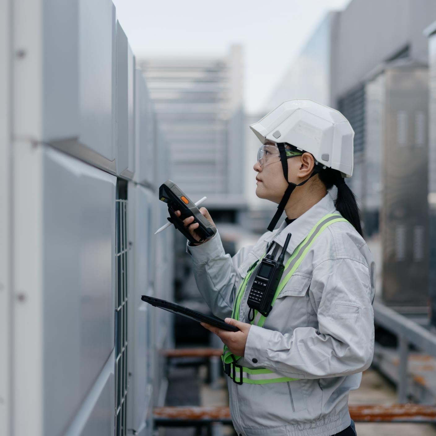 A female engineer is checking the operation of the air conditioner