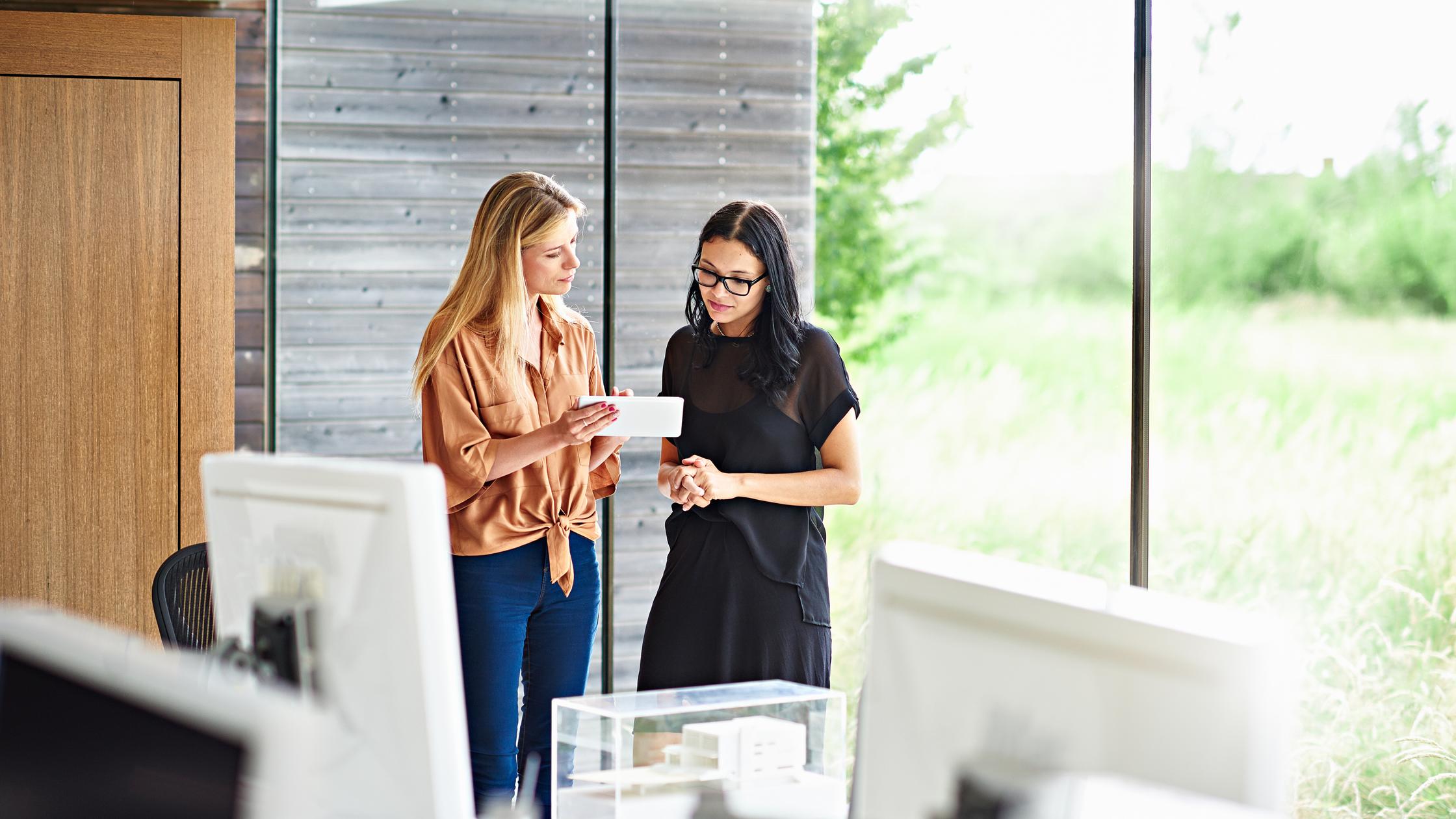Two women in meeting looking at tablet