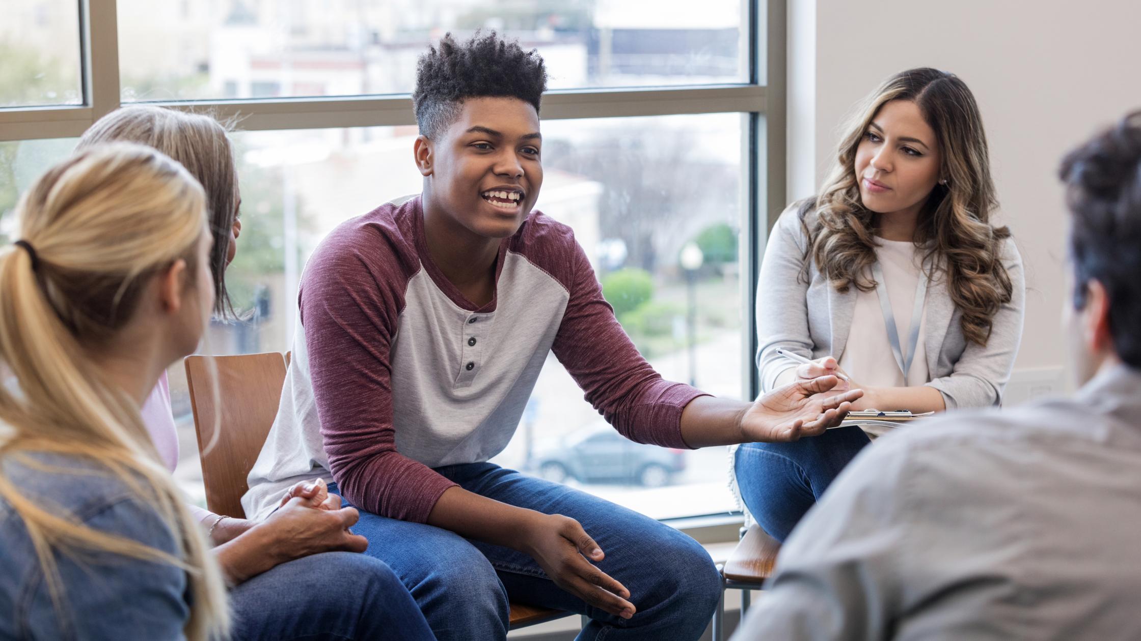 A teen boy shares his problem with a therapy group.